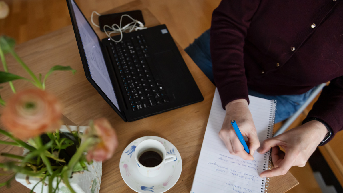 En person filar på cv:t vid sin dator.