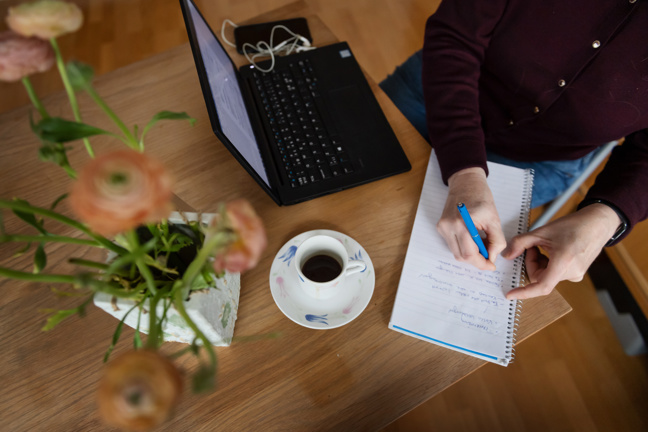 En person filar på cv:t vid sin dator.