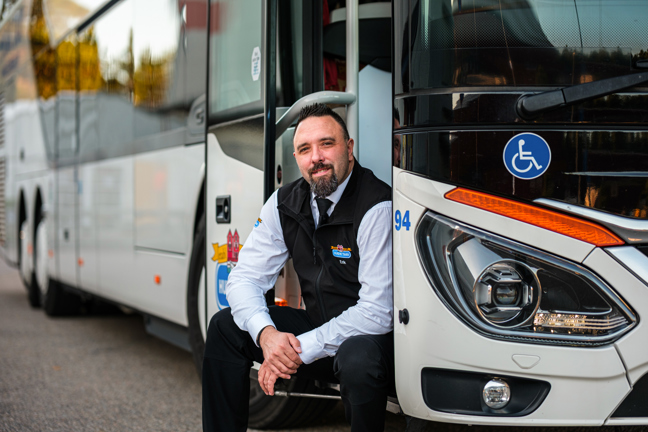 Erik Karlsson sitter på trappsteget till sin buss.