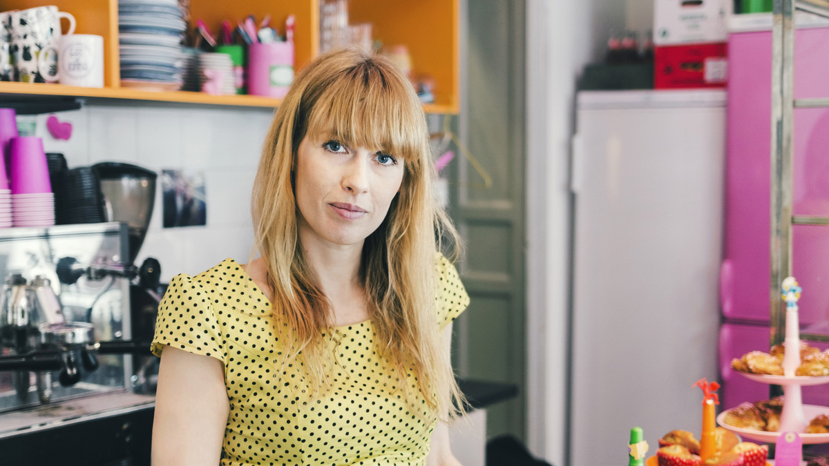 Kvinna i kassan på kafé.