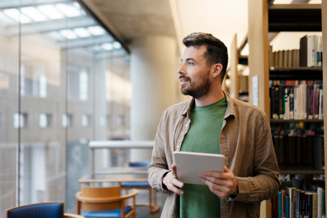 Ung man tittar ut genom fönstret.