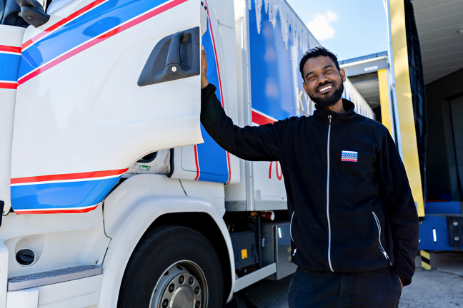 Yosief Abrha håller upp dörren till sin lastbil.